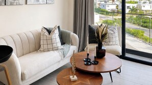 Ein modernes Wohnzimmer mit Sofa, Couchtisch und Kunstwerken an der Wand.