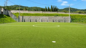 A soccer field with goalposts, surrounded by a fence and a wall. - Santa Tecla | Modern high-floor apartment (Santa Tecla)