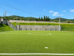 A soccer field with goalposts, surrounded by a fence and a wall. - Santa Tecla | Modern high-floor apartment (Santa Tecla)