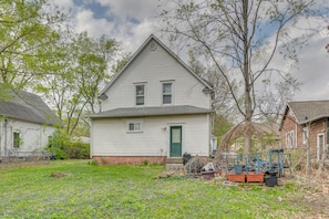 A two-story house with a green door, a small porch, and a garden with flowers. - < 1 Mi to UIUC! Family Game Day Hub w/ Large Yard (Champaign)