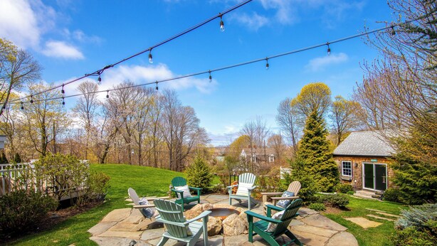 A patio with stone flooring, green Adirondack chairs, and a fire pit. - Ping-Pong & Fire Pit! Renovated Marshfield Cottage (Marshfield)