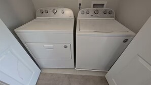 Une buanderie équipée de deux machines à laver à chargement frontal et d’un sèche-linge.