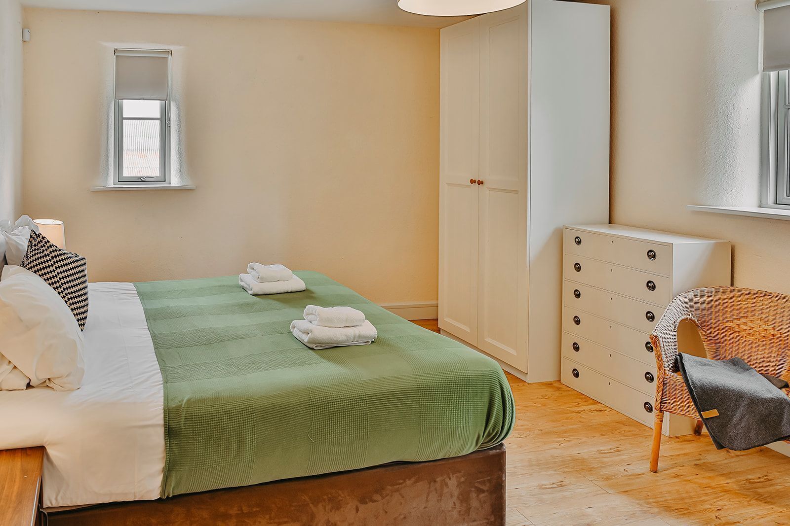 Une chambre à coucher avec un lit, une armoire, une chaise et un radiateur.