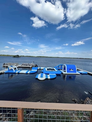 A calm lake with floating platforms, a dock, and a clear sky.