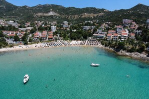 Eine Küstenstadt mit Strand, Booten und Gebäuden.
