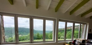 Ein Zimmer mit großen Fenstern und Blick auf eine Berglandschaft.
