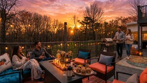 Une terrasse avec coin salon extérieur, un barbecue et une vue imprenable sur le coucher de soleil.