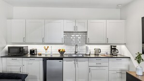 A modern kitchen with white cabinets, a stainless steel sink, a microwave, a toaster, and a coffee maker. - Red Rock Nook by Avantstay West Sedona Retreat Near Trails + Dining + Mountain Views (Sedona)