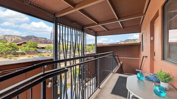 A balcony with a view of a parking lot and mountains.
