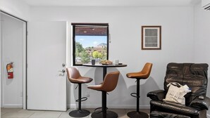 A room with a door, a window with a view, two chairs, a table, and a sofa. - Red Rock Nook by Avantstay West Sedona Retreat Near Trails + Dining + Mountain Views (Sedona)