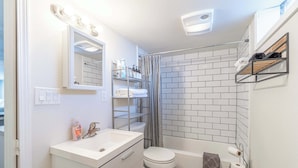 Un baño con lavamanos blanco, inodoro y zona de ducha.