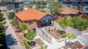 A residential house with a red roof, a front porch, and a small garden area. - Midtown Sanctuary w Pac-Man! (Reno)