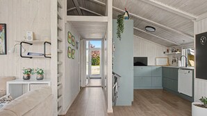 A modern kitchen with light blue cabinets, a black refrigerator, and a hanging plant. - "Sote" - 330m from the sea by Interhome (Otterup)