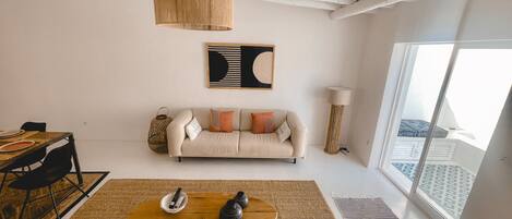 A modern living room with a sofa, coffee table, and a large window.