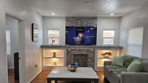 A living room with a fireplace, a flat-screen TV, a coffee table, and a couch. - Central Close to Downtown, Airport, Fort bliss, Restaurants , Entertainment,UTEP (El Paso)