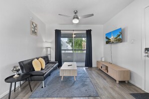 Un salon moderne avec un canapé, une table basse et un téléviseur.