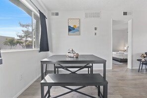 Un salon moderne avec une table à manger, un canapé et une vue sur l’extérieur.