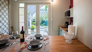 En matplats med ett bord dukat för fyra personer, en vinflaska och utsikt över omgivningen.
