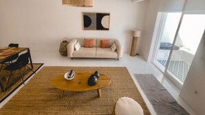 A modern living room with a sofa, coffee table, and a large window. - Casa Pura Vida By Gt House (Reguengos de Monsaraz)