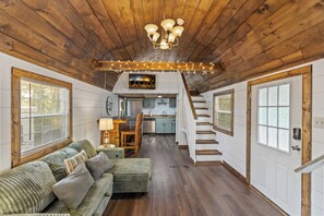 A cozy interior with a wooden ceiling, a staircase, a kitchen, and a seating area. - New Tiny Home + Camper - Sleeps up to 10 - Fire Pits - Access to Brimstone Trail (Huntsville)