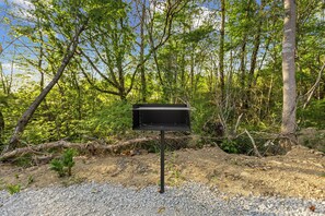 A mailbox in a natural setting with trees and gravel. - New Tiny Home + Camper - Sleeps up to 10 - Fire Pits - Access to Brimstone Trail (Huntsville)