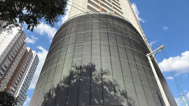Um edifício moderno com fachada curva, entrada imponente e um grande letreiro com o número 181.
