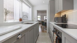 Een moderne keuken met een spoelbak, fornuis en een eethoek.