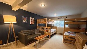 A room with a bunk bed, a sofa, a coffee table, a lamp, and a dresser. - Cozy 3-bedroom townhome in West Dover, steps from the magic carpet (Dover)