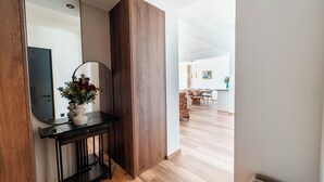 Een modern interieur met een houten consoles en een spiegel, en een vaas met bloemen.