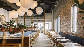 A restaurant with long tables, wooden chairs, hanging paper lanterns, and potted plants. - House with Rooftop Patio, Next to a Park, 3 Miles to Downtown (Nashville)