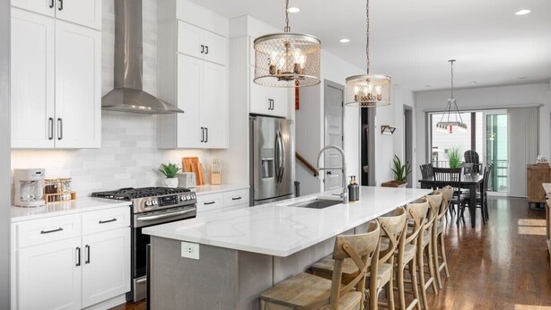 A modern kitchen with white cabinets, stainless steel appliances, and a central island with bar stools. - House with Rooftop Patio, Next to a Park, 3 Miles to Downtown (Nashville)