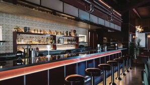 A bar area with stools, a counter, and a variety of bottles. - House with Rooftop Patio, Next to a Park, 3 Miles to Downtown (Nashville)