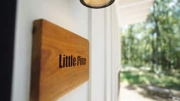 Un letrero de madera con el texto 'Little Pine' colocado en una puerta blanca.