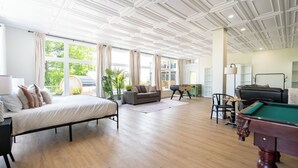 A spacious room with a bed, a sofa, a pool table, and a desk with a computer. - Souvenir  (Chelsea)