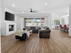 Una sala de estar moderna con chimenea, sofá y comedor.