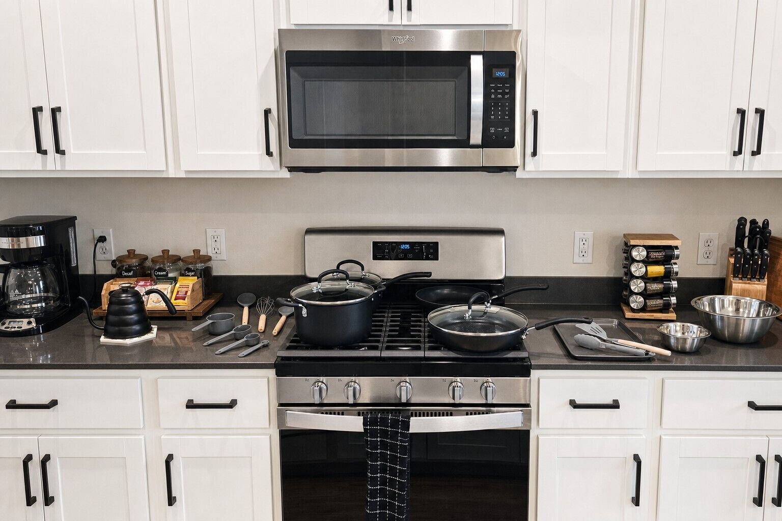 A modern kitchen with stainless steel appliances, including a microwave and stove, and various cooking utensils and ingredients on the counter.
