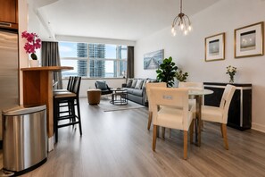 A modern living room with a dining area, a sofa set, a coffee table, and a view of high-rise buildings. - AKA Brickell  (Miami)