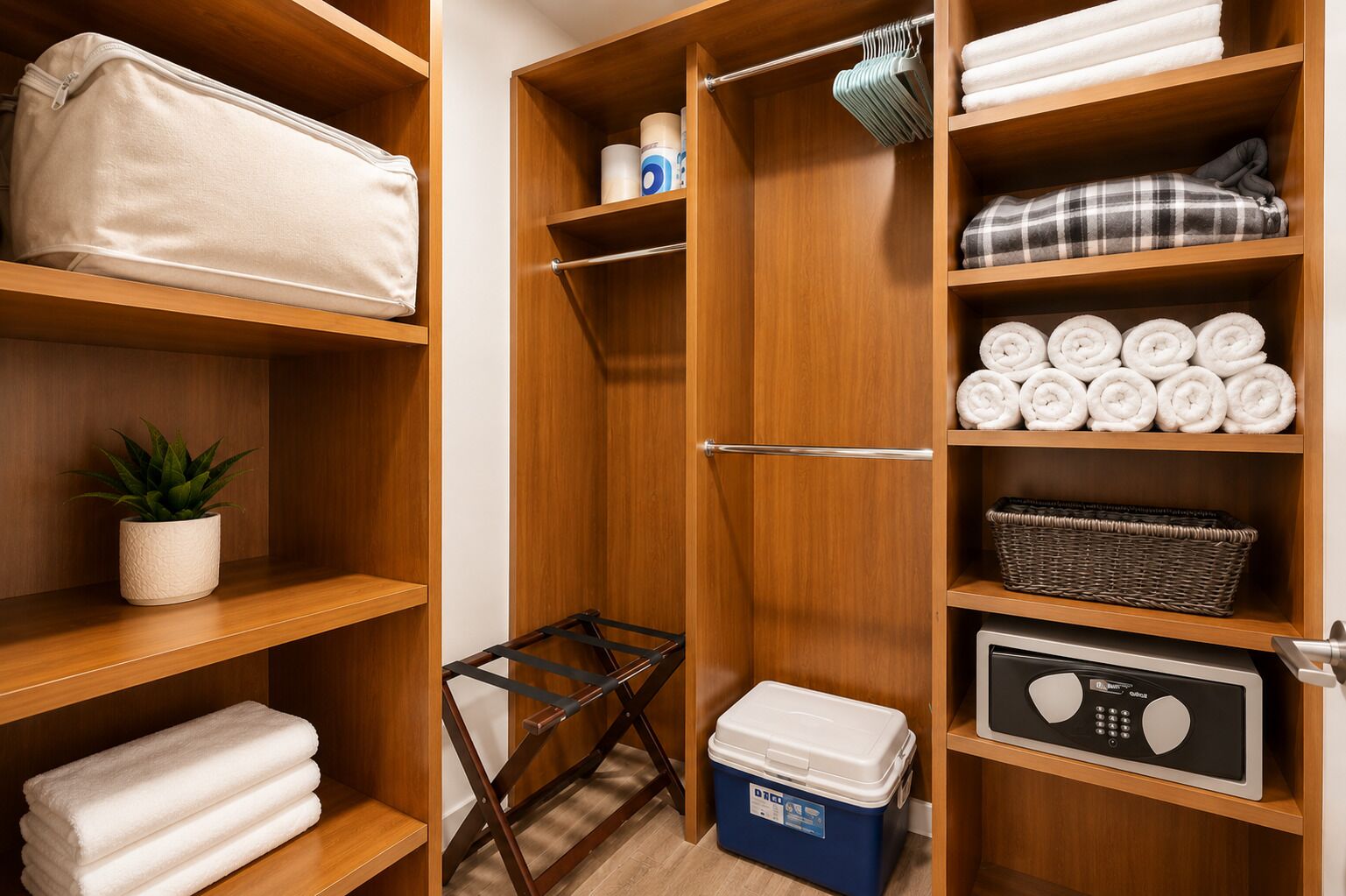 Un placard en bois avec des étagères où sont rangées des serviettes pliées, un panier et un radiateur portatif.