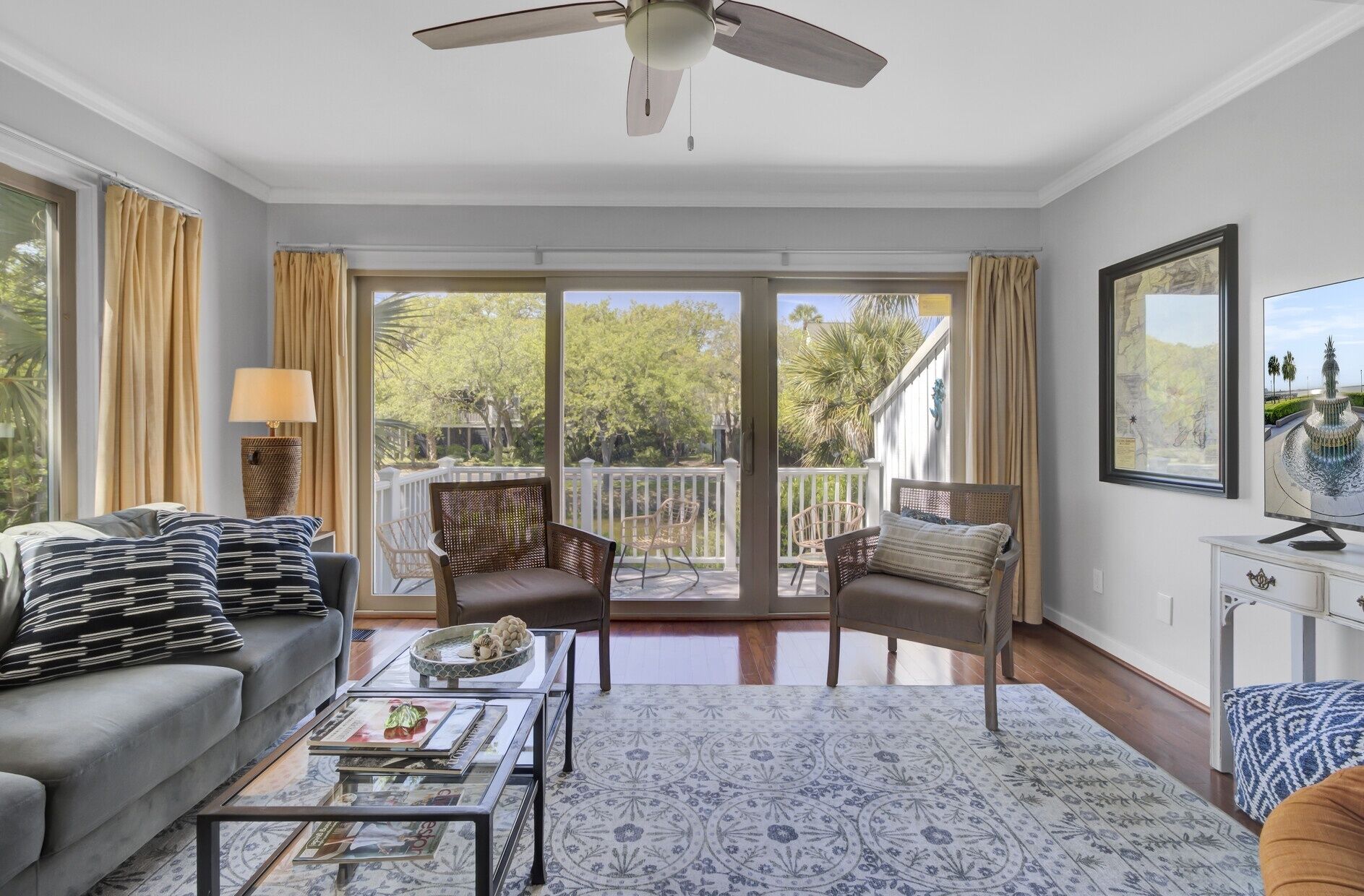 A spacious living room with a sofa, armchairs, a coffee table, and a television.