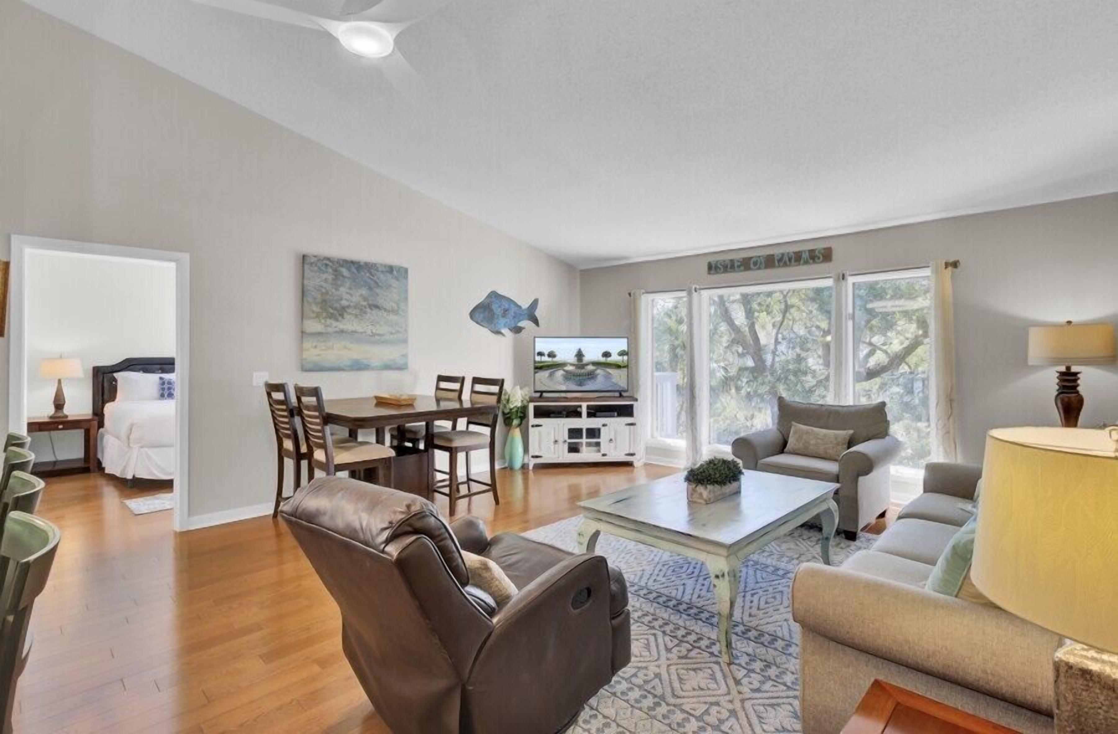 A spacious living room with a sofa, coffee table, and a dining area with chairs and a table.