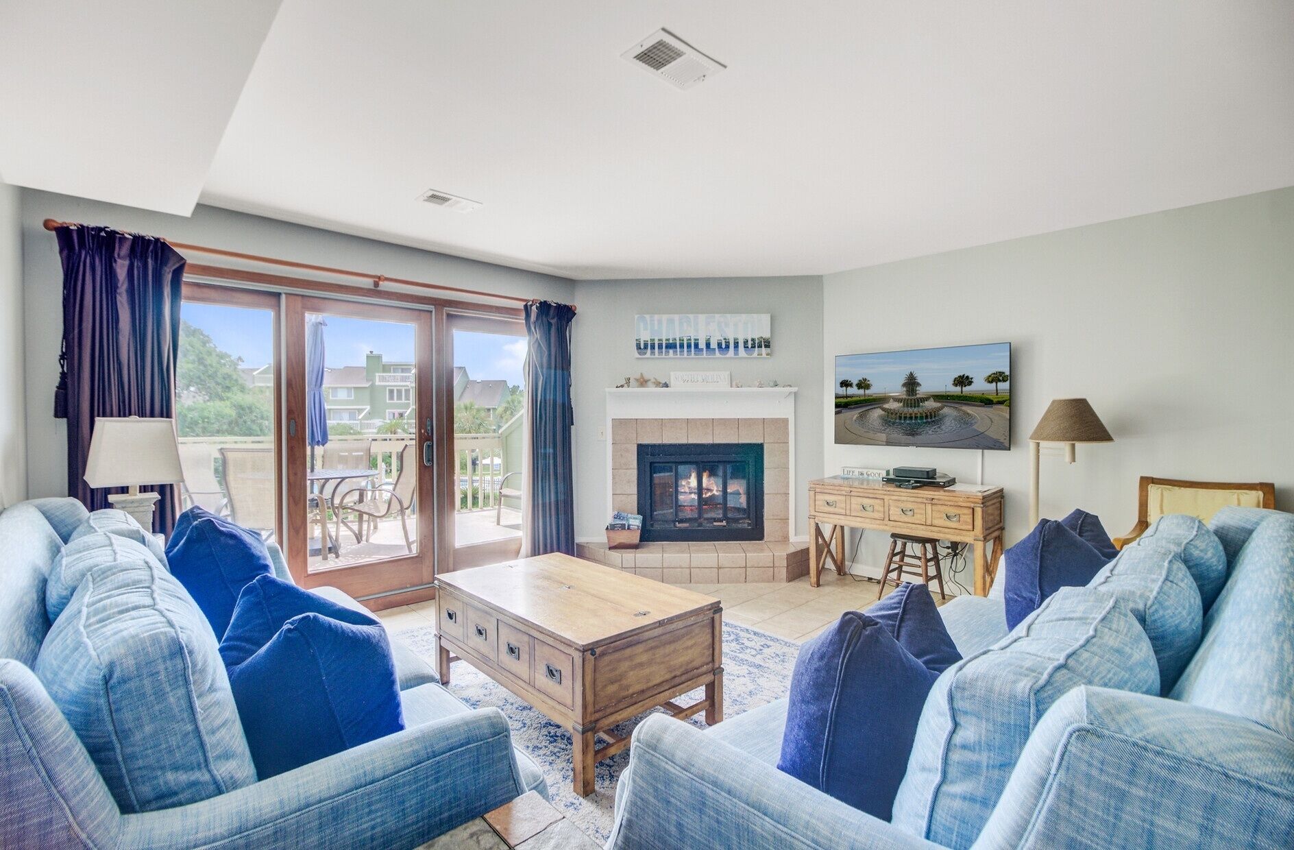 Una sala de estar con chimenea, televisor y vistas al exterior.