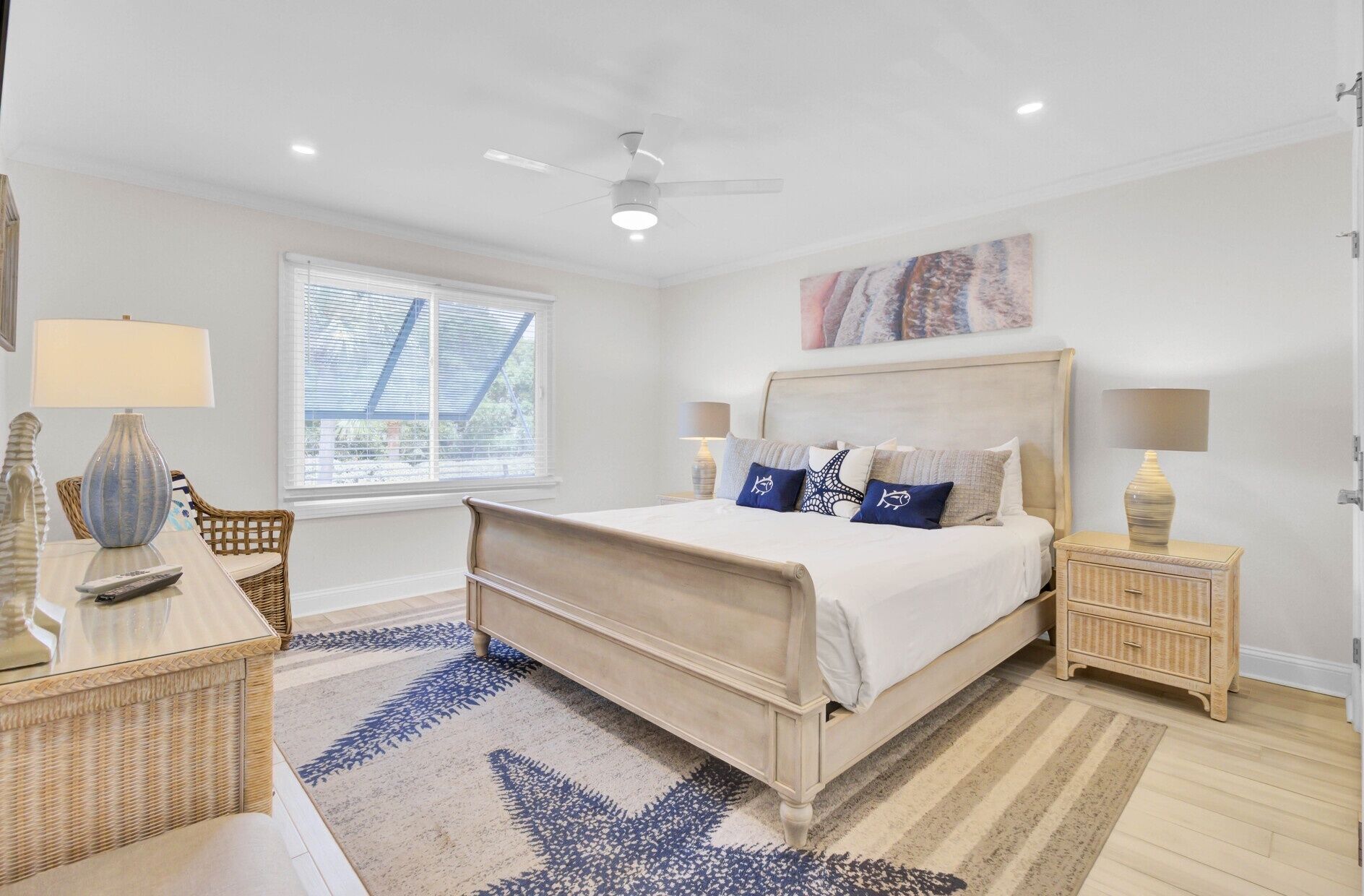 A bedroom with a bed, a window, a ceiling fan, and a nightstand.