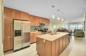 A modern kitchen with wooden cabinets, stainless steel appliances, and a central island. - Wild Dunes Vacation Condos 3&4 Bedrooms (Isle of Palms)