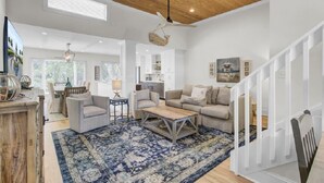 A spacious living area with a wooden ceiling, a large rug, and a staircase. - Wild Dunes Vacation Condos 3&4 Bedrooms (Isle of Palms)