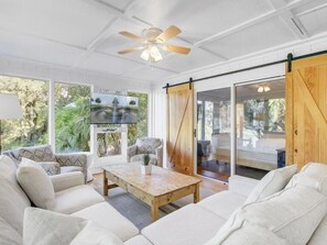 A spacious living room with a large sofa set, a wooden coffee table, and a ceiling fan. - Wild Dunes Vacation Homes 3&4 Bedrooms (Isle of Palms)