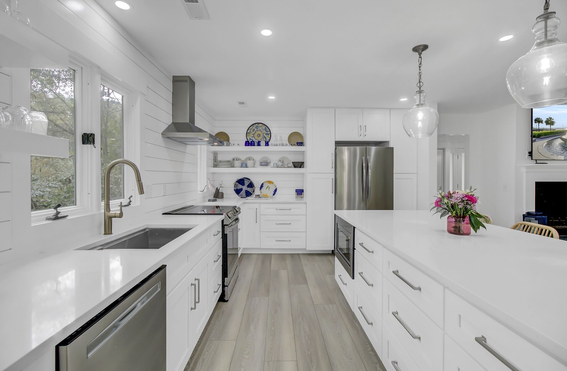 A modern kitchen with white cabinetry, stainless steel appliances, and a central island.