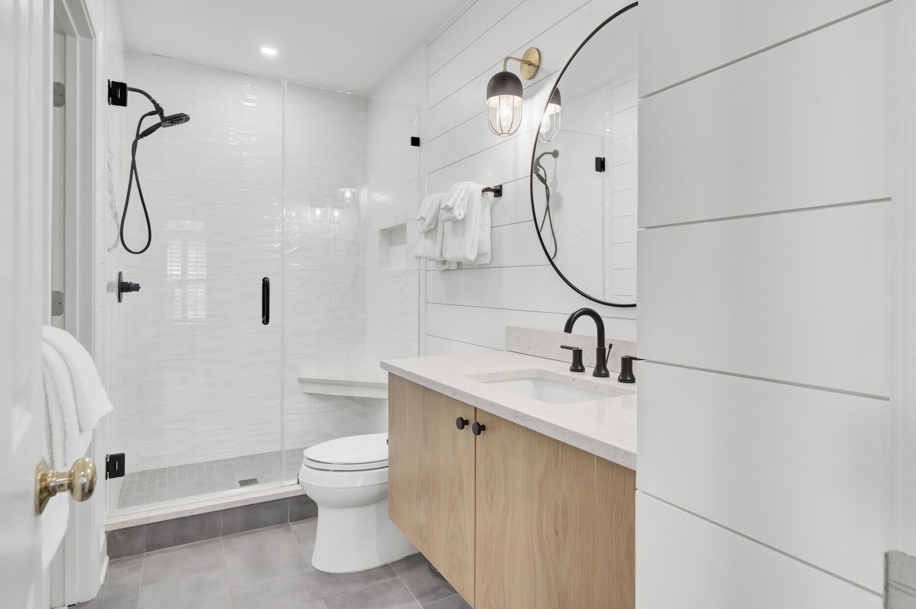 A modern bathroom with a shower, toilet, and vanity.