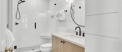 Un baño moderno con ducha, inodoro y tocador.