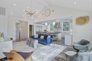 A spacious living area with a blue sofa, a wooden chair, and a round coffee table. - Wild Dunes Vacation Homes 3&4 Bedrooms (Isle of Palms)