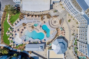 Oversigtsbillede af et resort med flere swimmingpools, liggestole og et stort overdækket område.